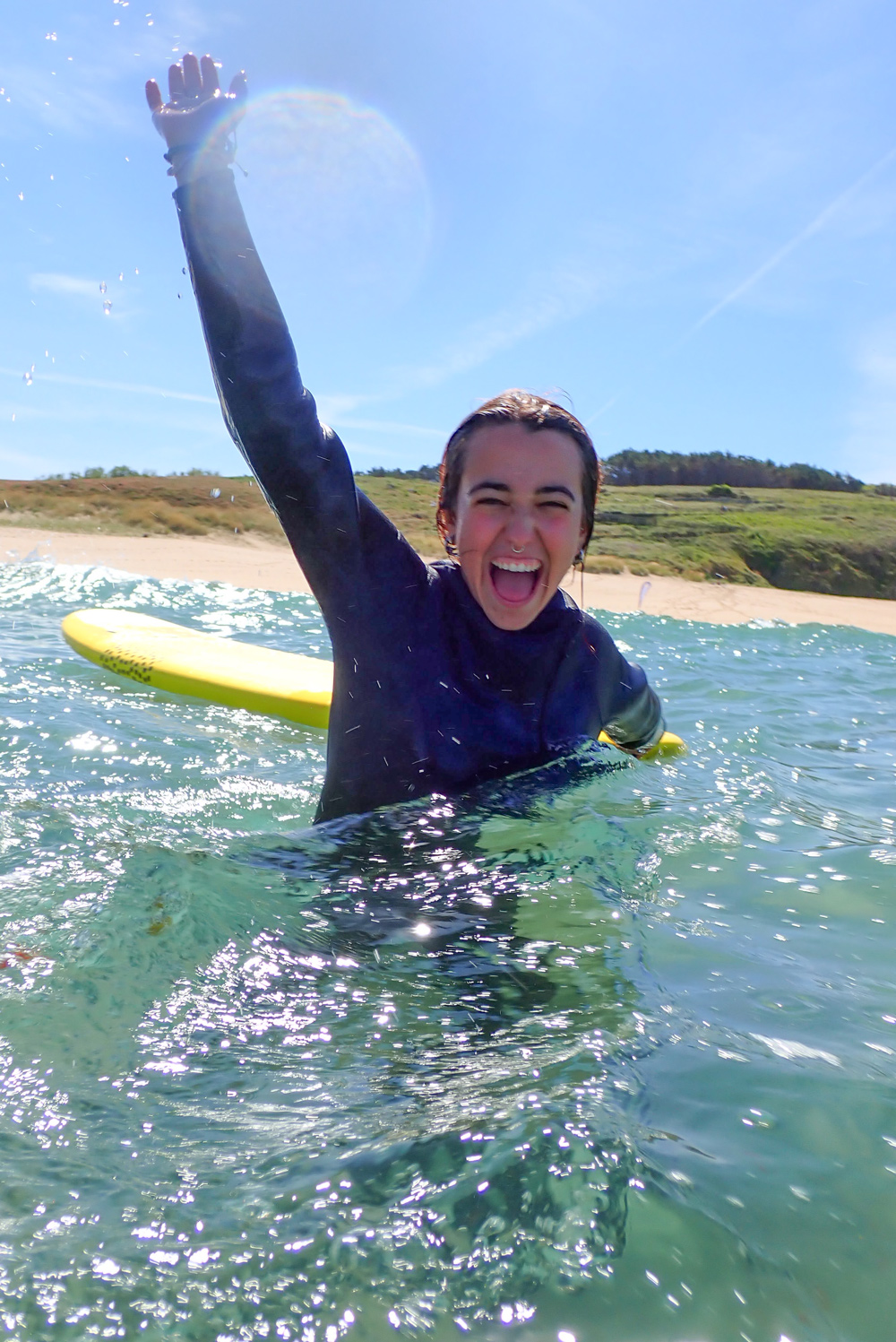 Alumna sonriendo tras una clase de surf en Fisterra.